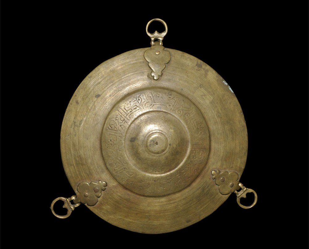 Islamic Bronze Epigraphic Kufic Scale Pan: Circa 18th-19th century AD A bronze scale pan with three attachment loops; concentric ring detailing to the interior; to the underside three lobed carrier plates for the loops and a band of Kufic scri