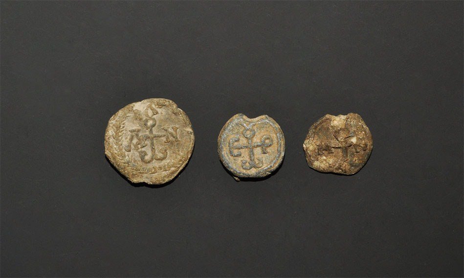Byzantine Lead Seal Collection: 5th-8th century AD A mixed group of discoid seals comprising: one with cross motif linking alpha and nu, to the reverse a monogram; one with nimbate bust, to the reverse crossed anchors; one with bear