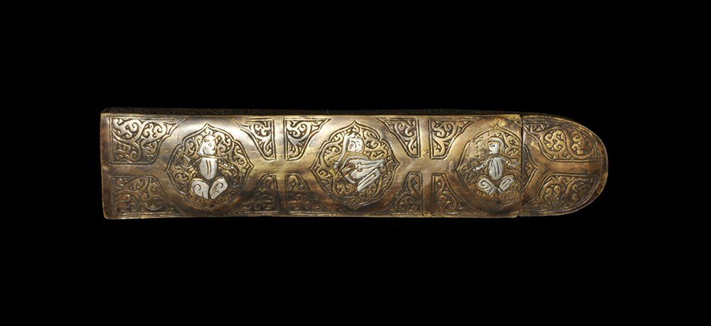 Islamic Style Bronze Pen Box with Silver Inlay: An undated archaistic sheet bronze pen box with sliding tray; the upper face decorated with arabesque detailing, three silver-inlaid seated figures; the edge with foliate background, silver-inlaid cal
