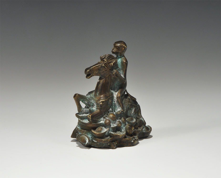 Chinese Bronze Monkey on Horseback Figurine: 20th century AD. A hollow cast figurine displaying attributes of good fortune and professional good luck: a monkey riding a horse on a bed of coins and fruit carrying a basket of peaches. 612 grams, 1