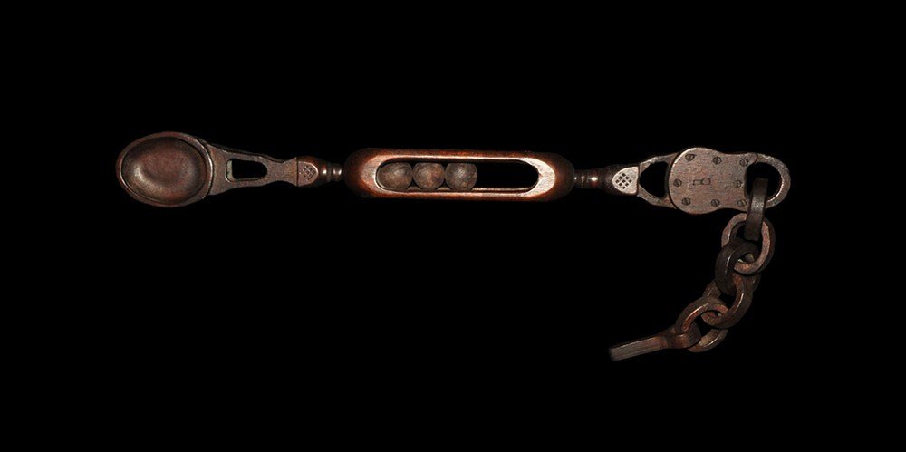 Post Medieval Wooden Symbolic Spoon: 20th century AD. A carved spoon with elaborate detailing to the handle; the bowl and openwork shaft joined by a balustered element to an openwork cage with three balls rising to a simulated padlock wi