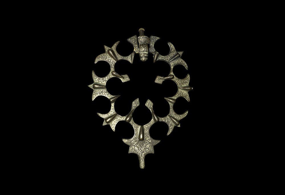 Islamic Style Bronze Door Knocker: An undated archaistic Islamic style cast bronze door knocker formed as radiating trefoil spokes with ovoid lobes to the upper face; the surface detailed with arabesque tendril ornament and silver stud