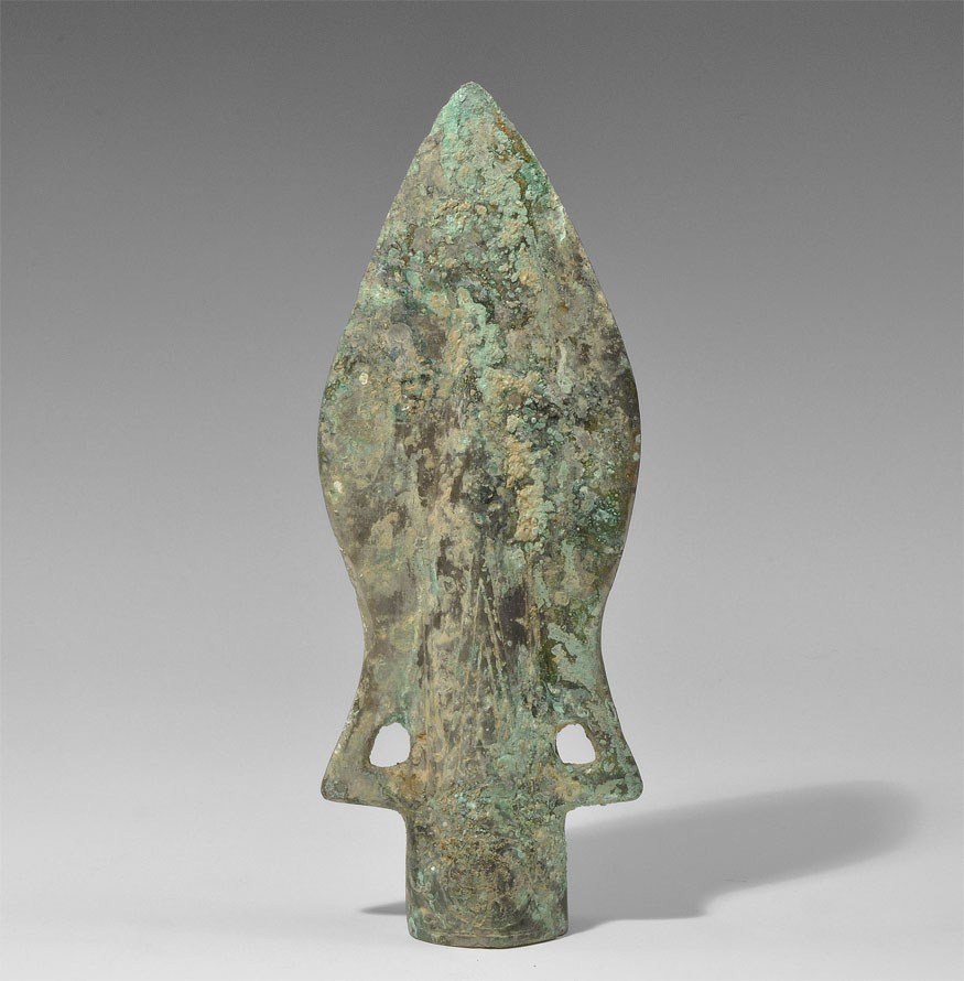 Chinese Warring States Style Bronze Spearhead: An undated archaistic bronze socketed spearhead in 475-221 BC style, the lanceolate blade with decorated central ridge, the socket decorated with scroll and circle pattern, a loop each side of the soc