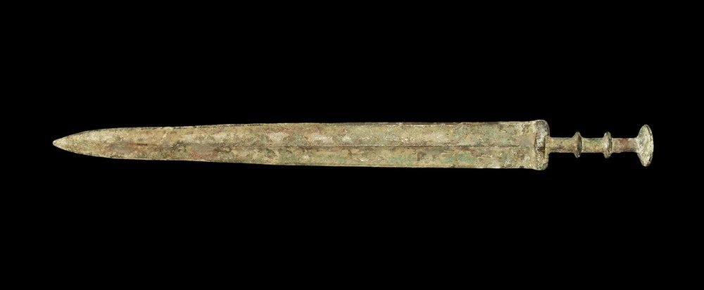 Chinese Style Bronze Han Sword: An undated archaistic cast sword in Han Dynasty style with gently tapering blade, slightly waisted above the tip; the hilt columnar with two flanges to the grip and larger concave flange pommel above;