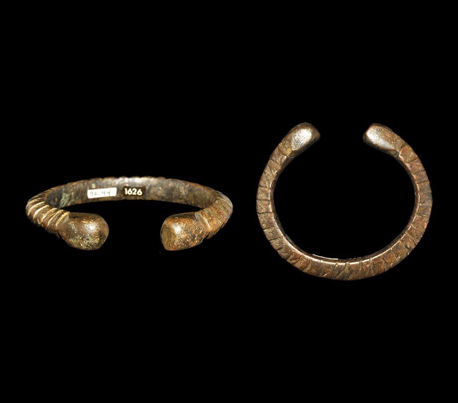 Chinese Bronze Bracelet from the Hattatt Collection: Zhou Dynasty, 1046-256 BC. A cast penannular bracelet formed as a D-section band with radiating ribs to the upper faces and polyhedral terminals. 49 grams, 45 mm (1 3/4"). See Hattatt, R. Ancient Broo