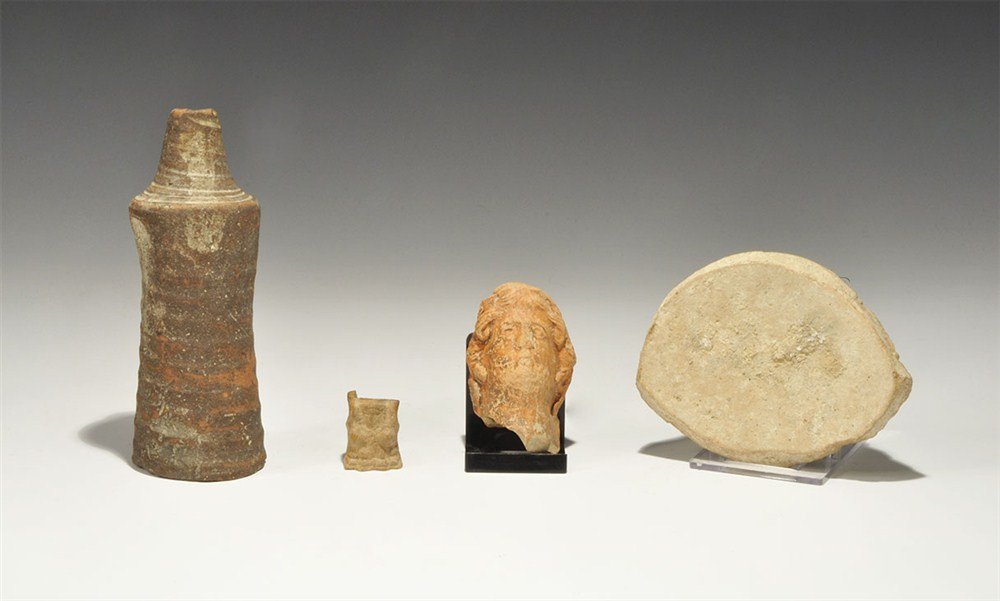 Roman Ceramic and Bone Artefact Group: 1st-4th century AD. A mixed group of artefacts comprising: a ceramic creamware pot base with old label 'From the ruins of Carthage 28/11/03'; a ceramic bell-shaped tube with old label 'Carthage 1905';