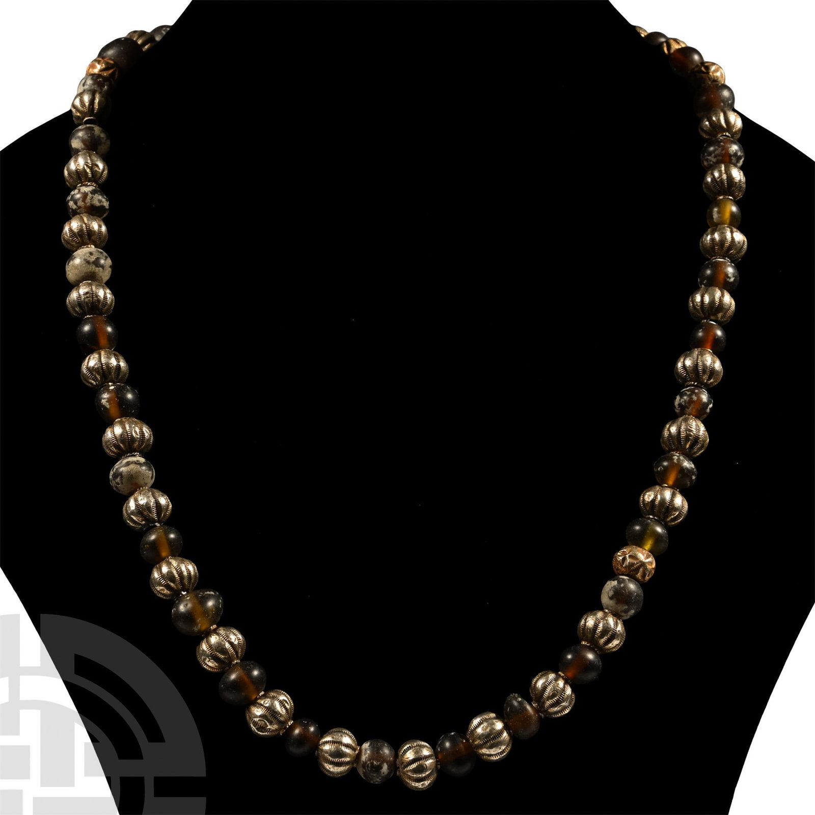 Glass and Silver Bead Necklace: 1st millennium A.D. and later. Restrung, composed of brown oblate glass beads with silver melon beads between; garnet and blue glass spool-shaped bead finials. 94 grams, 57.5 cm (22 5/8 in.). [No Rese
