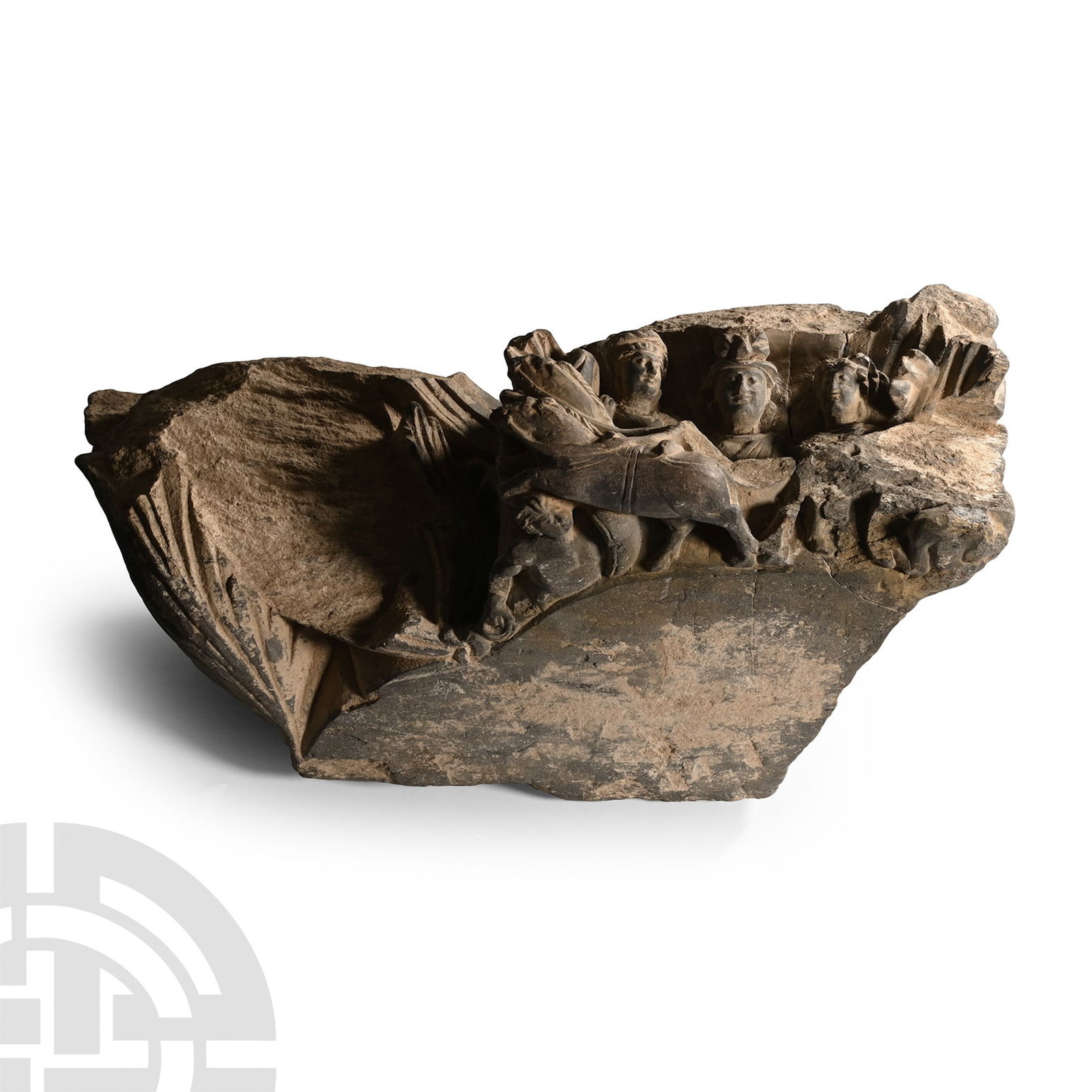 Gandharan Schist Frieze Fragment: 2nd-4th century A.D. or later. Carved corbel or column fragment with scrolled foliage to three faces and socket to upper face to accept a statue; three youthful figures - two females flanking a larger