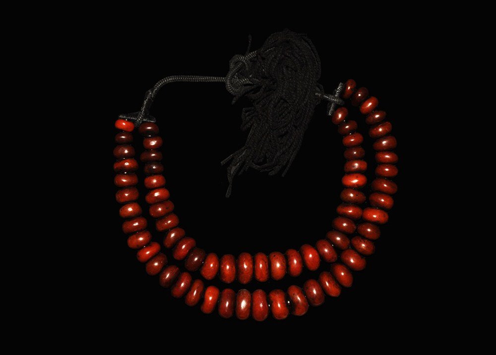 Islamic Style Massive Reconstituted 'Amber' Bead Neckla: A restrung necklace of large discoid reconstituted amber beads on a braised black wool band. 3.2 kg, 152 cm (60"). Acquired on the London art market in the 1960s; believed from Marrakesh.