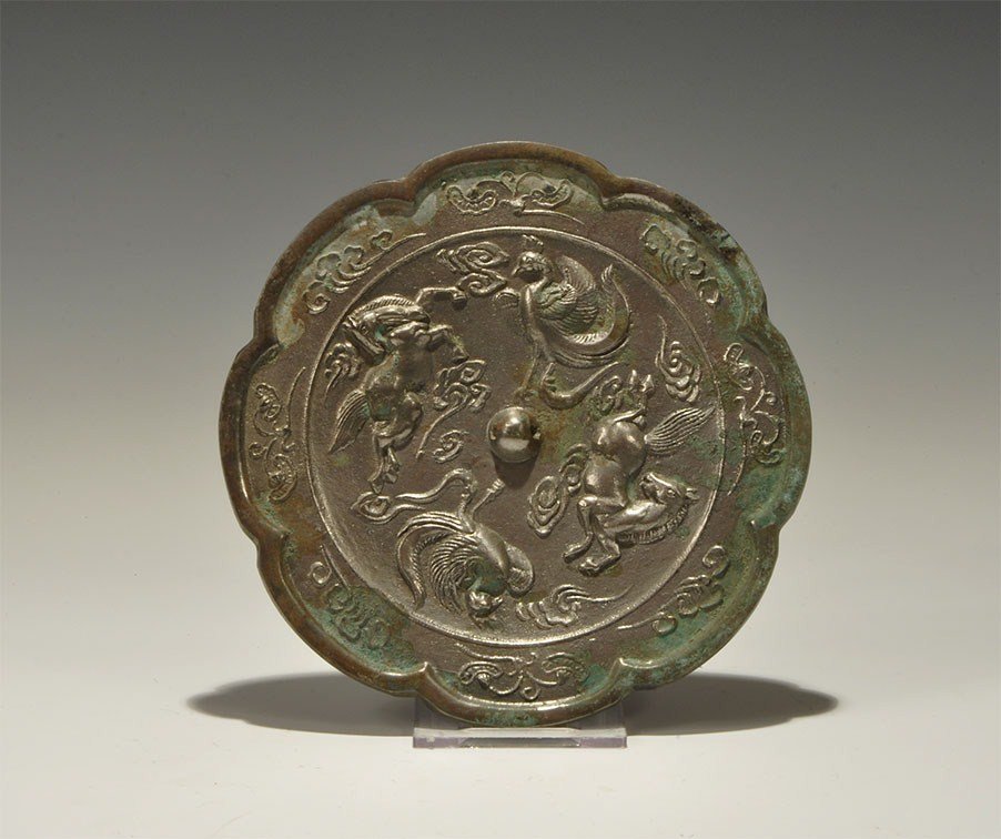 Chinese Style Bronze Mirror: An undated archaistic discoid mirror with one polished face and rosette profile; to the reverse a central pierced lug surrounded by running horse and bird motifs, foliate band surrounding. 455 grams,