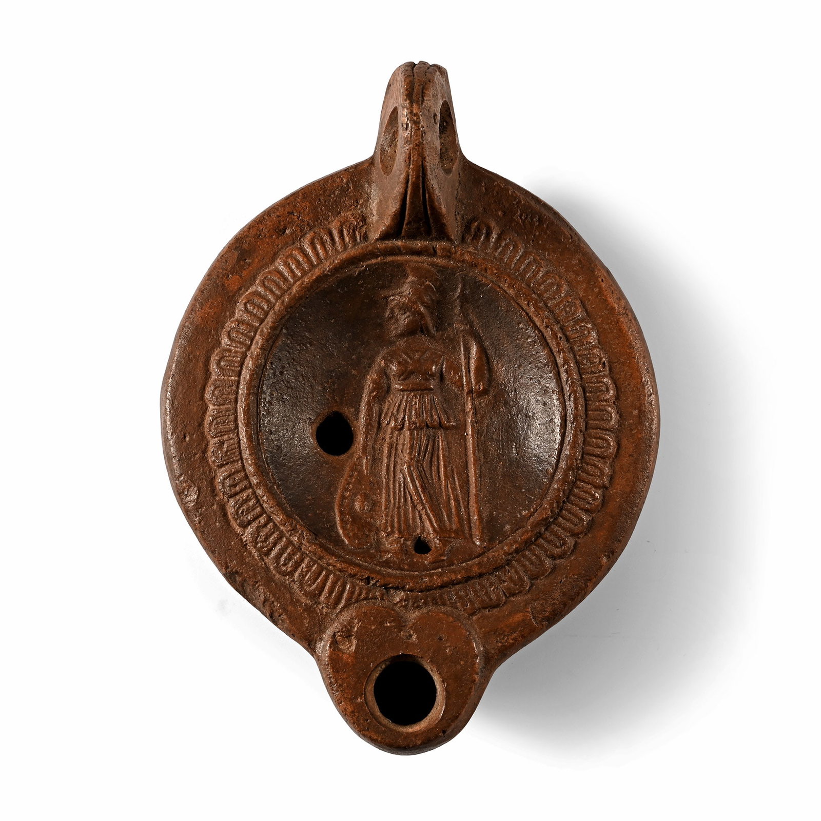 Roman Terracotta Lamp with Minerva: 1st-2nd century A.D. Comprising a pierced lug handle and short nozzle; shoulder with band of radiating feathers, discus with Minerva standing facing wearing a cuirass and holding spear and shield; con