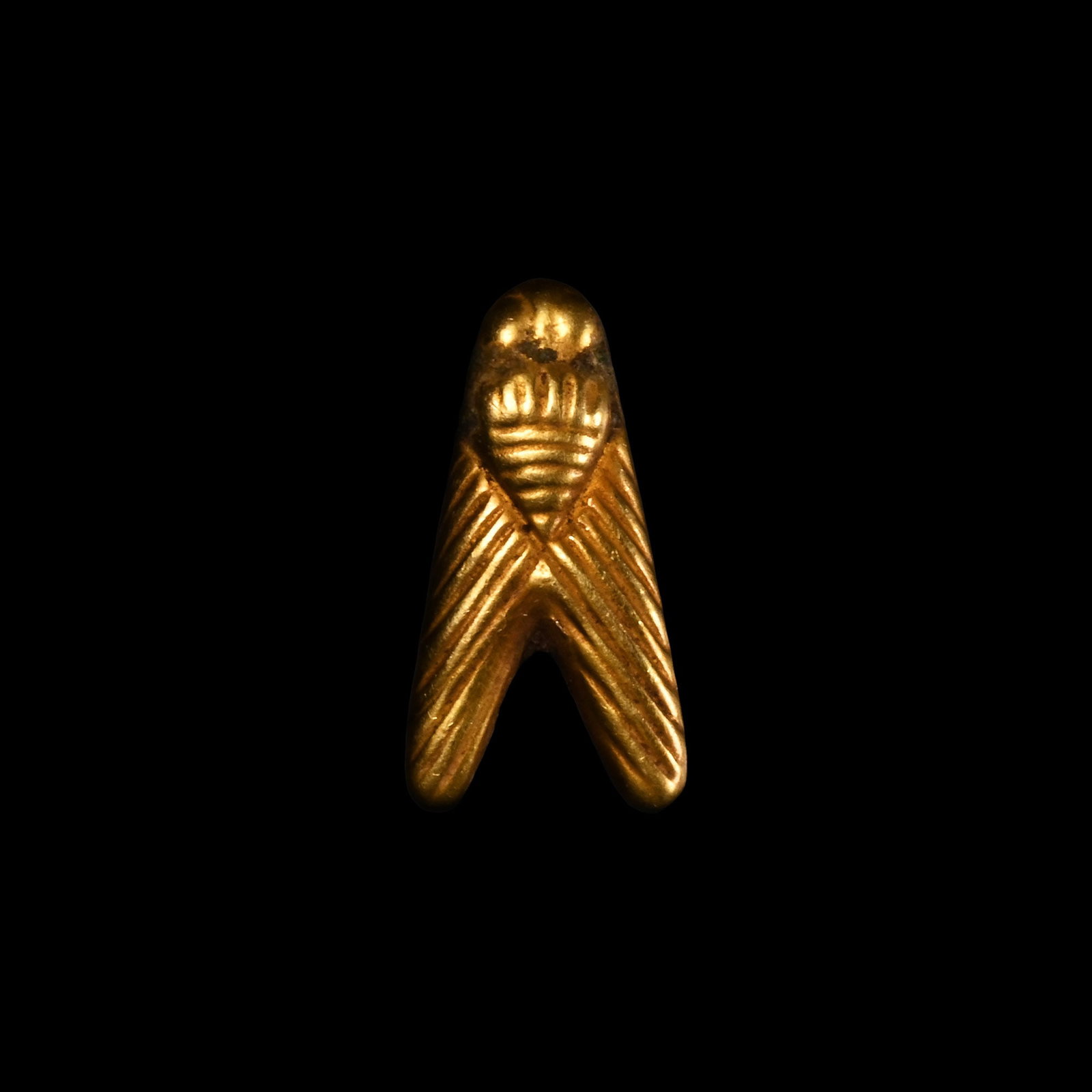 Egyptian Gold Fly Amulet: Late Period, 664-332 B.C. Chevron-shaped pendant with incised detailing to the body and wings. Cf. Andrews, C., Amulets of Ancient Egypt, London, 1994, fig. 48, for similar examples of gold flies. 1.7