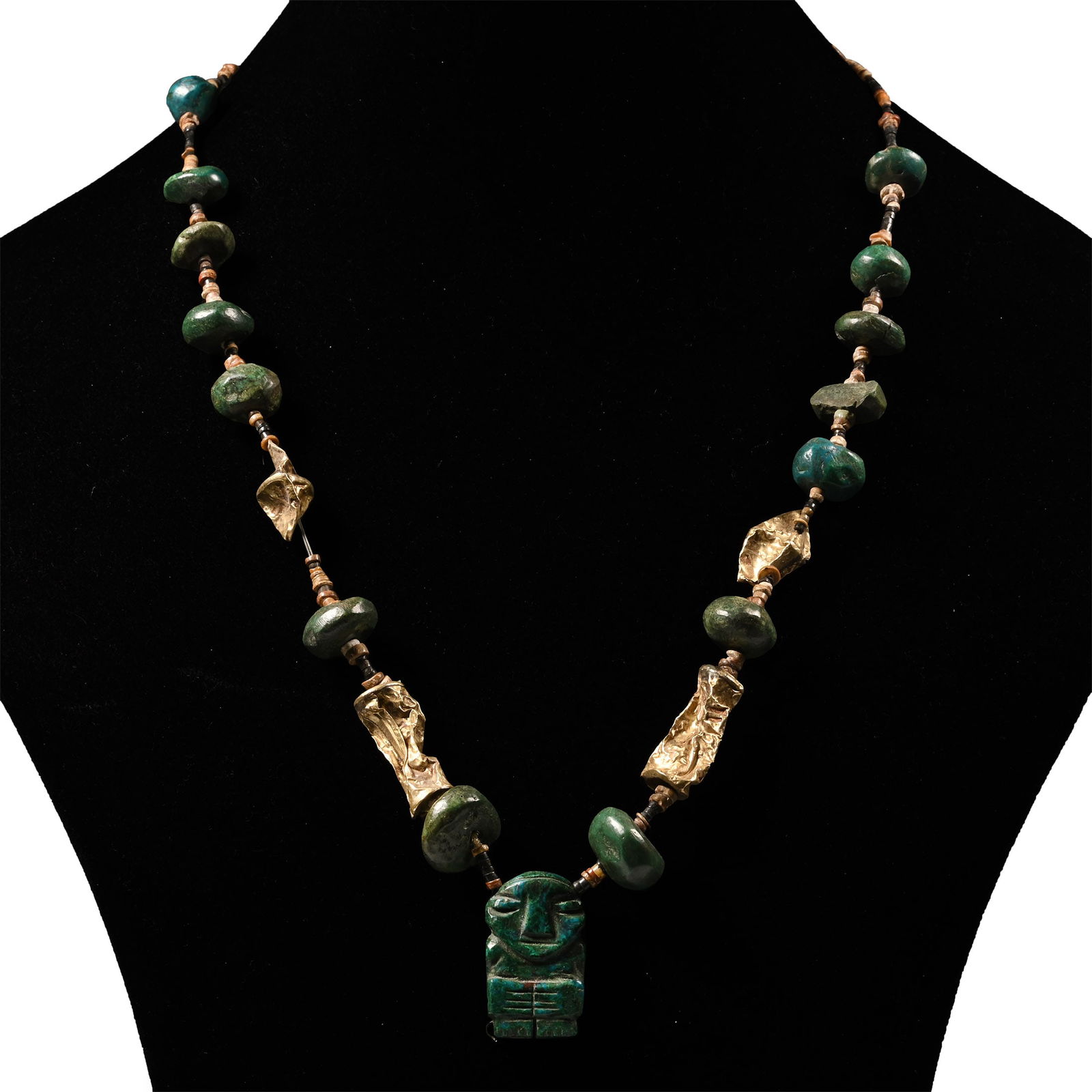 Pre Columbian Jadeite and Gold Bead Necklace: Early 20th century A.D. or earlier Restrung group of oblate, polyhedral and other beads with interstitial spacer beads and hollow sheet-gold fusiform beads; centrepiece an anthropomorphic pendant. 52