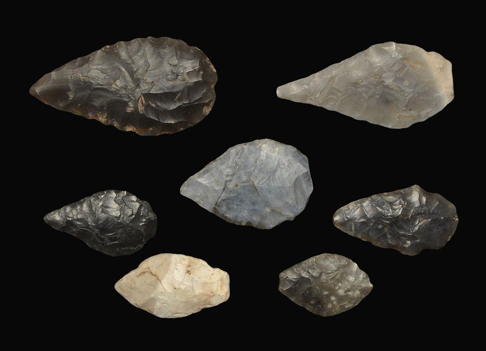 Stone Age Flint Arrowhead Collection: Neolithic, 5000-3000 BC . A group of seven leaf-shaped arrowheads comprising: a flint bifacial type with shallow side notches (inked reference 'Mildenhall'); a flint bifacial leaf type with slightly w