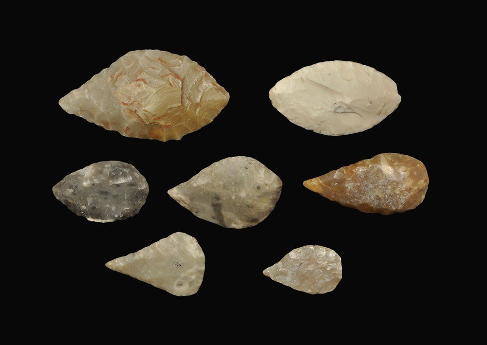Stone Age Flint Arrowhead Collection: Neolithic, 5000-3000 BC . A group of seven leaf-shaped arrowheads comprising: a flint oval type (inked reference 'Cheddar, Som'); a flint bifacial teardrop type (inked reference 'Suffolk'); a thick bu