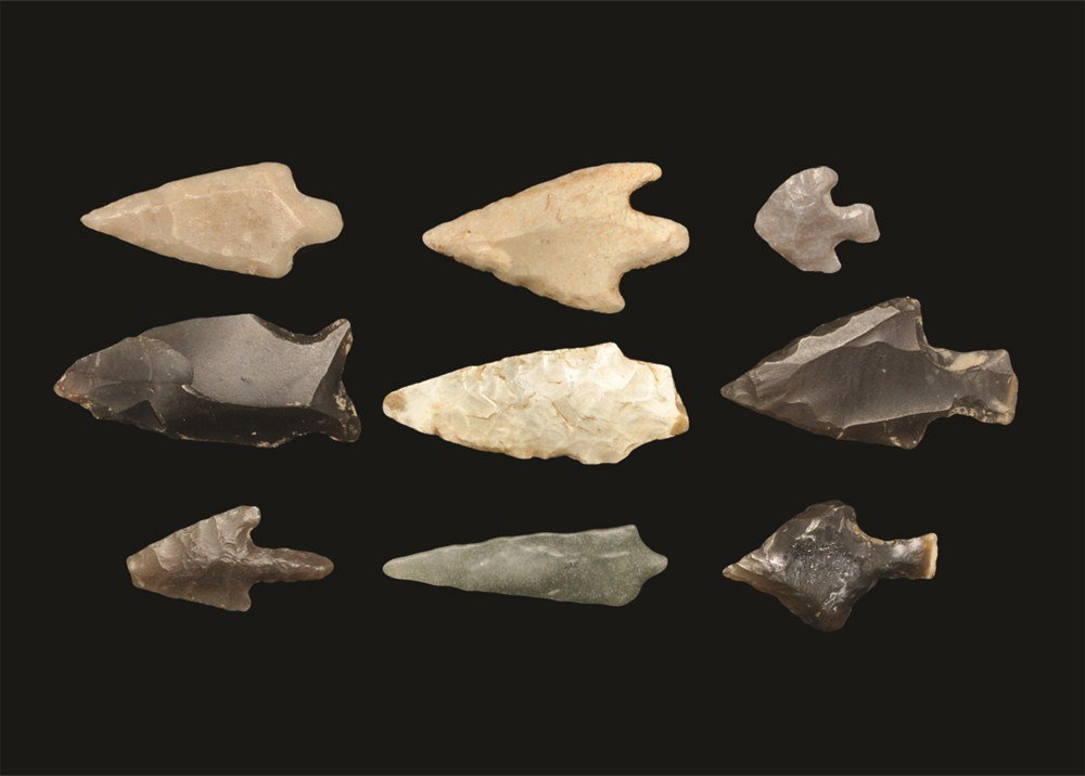 Stone Age Flint Arrowhead Collection: Neolithic, 4000-2500 BC . A group of nine arrowheads comprising: a greenstone elongated short-stemmed type (inked reference 'Norfolk'); a small flint barbed and tanged type (inked reference 'Marlow');