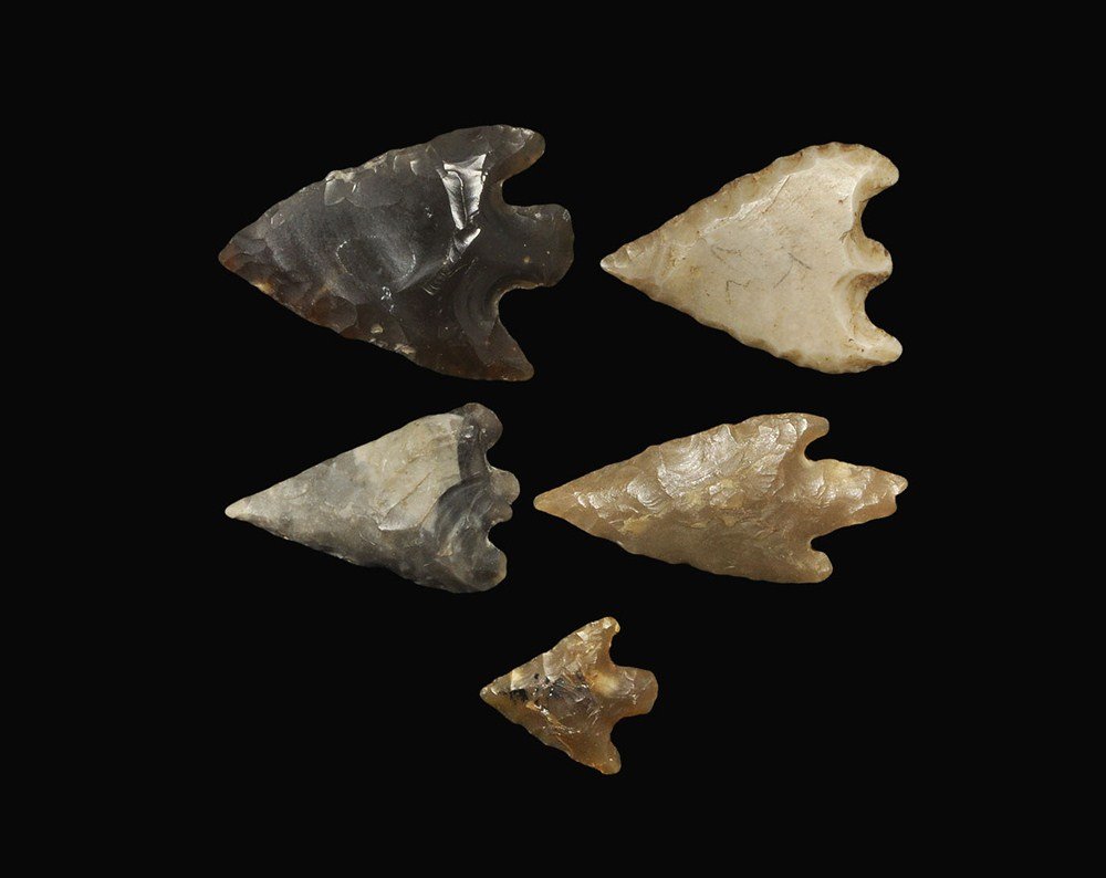 Stone Age Flint Arrowhead Collection: Neolithic to Early Bronze Age, 3000-2000 BC . A group of five arrowheads comprising: a heavy flint bifacial barbed and tanged type (found Ipswich, UK); a slender flint barbed and tanged type (inked re