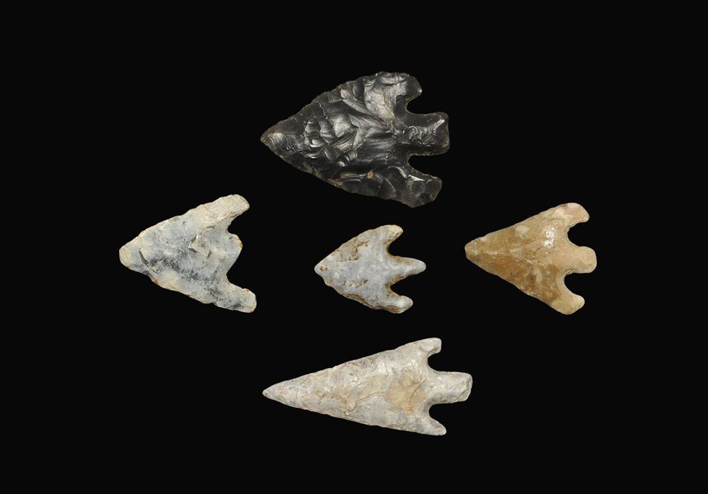 Stone Age Flint Arrowhead Collection: Early Bronze Age, 2400-1600 BC . A group of five barbed and tanged arrowheads comprising; a neatly formed flint bifacial angular type with blue-white patination with small chip to stem (PAS record SF-