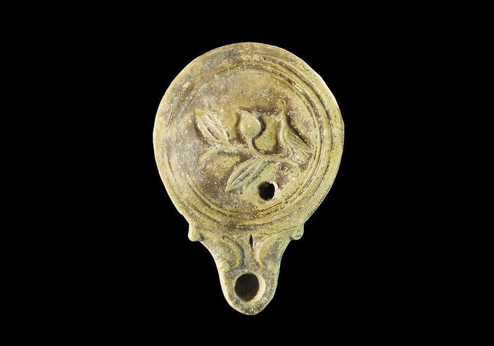 Roman Bird on Branch Oil Lamp: 1st-2nd century AD . A small ceramic oil lamp with D-shaped nozzle and moulded bird and olive branch motif to the discus; Asia Minor workmanship. 43 grams, 89 mm (3 1/2"). UK art market, acquired prio