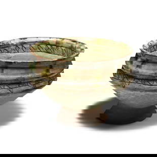 Byzantine Green Glazed Sgraffito Footed Bowl: 13th century A.D. Carinated in profile with narrow flared base, green-glazed upper body; to the inner face a central roundel with zigzag fill and a zigzag band above the gallery, to the outer face hor