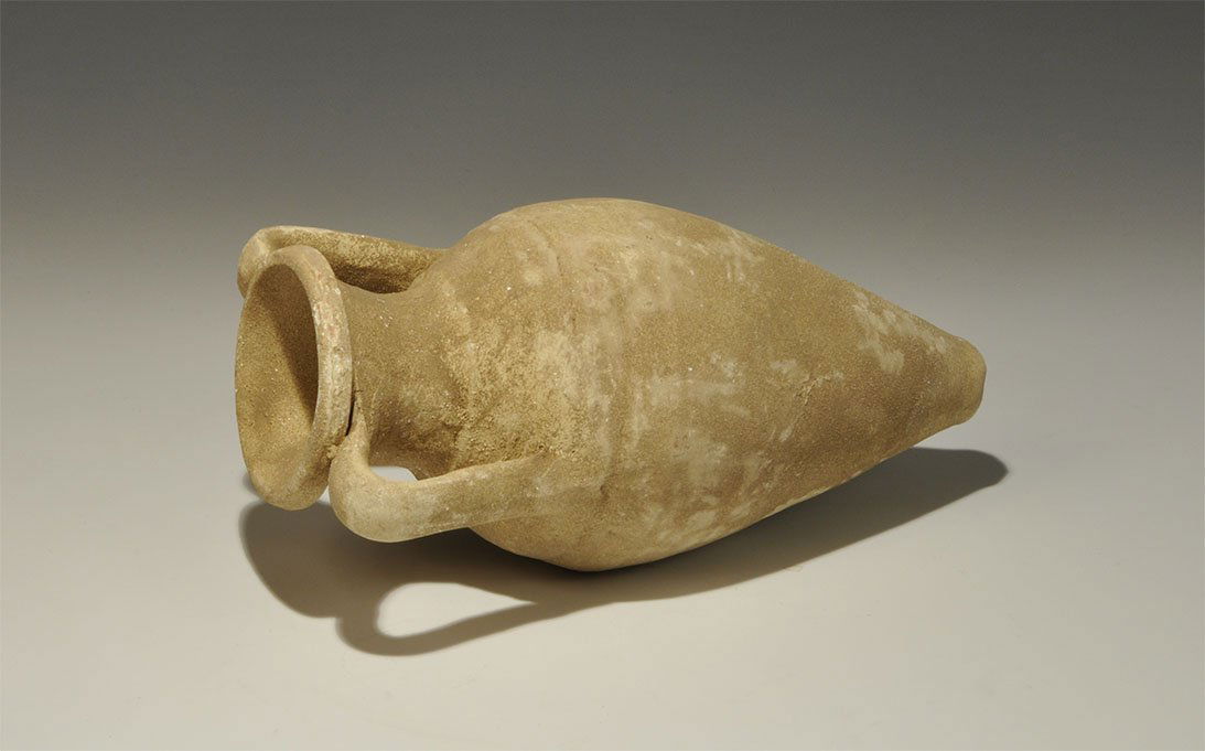 Romano Phoenician Ceramic Amphora: 5th-2nd century BC. A creamware amphora, piriform with low neck, rolled rim and two strap handles to the shoulders. UK art market, acquired prior to 1980. 741 grams, 24 cm (9 1/2").