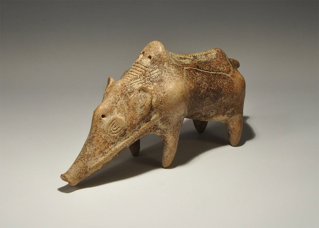 Bronze Age Anatolian Terracotta Boar Figurine: 2nd millennium BC. A hollow-cast terracotta boar with extended snout, ribbed ridge to the back and cheeks, pierced at the brow and shoulders. UK art market, acquired prior to 1980. 1.1 kg, 30 cm (11 3