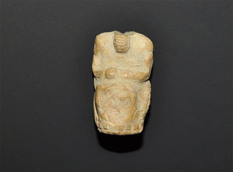 Near Eastern Sumerian Terracotta Idol Fragment: Circa 3000 BC. A ceramic idol depicting a seated figure in a long garment, hands clasped in the lap, beard on the chest; a billetted band to the edge of the garment. Ex Terence Eva collection. 17 gram