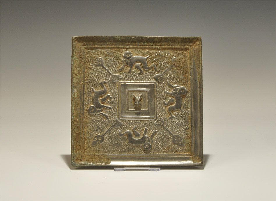 Chinese Style Bronze Square Figural Mirror: An undated archaistic square bronze mirror with one polished surface, the reverse with central pierced lug surrounded by a frieze of monkeys and staffs on a geometric background. Acquired on the Londo