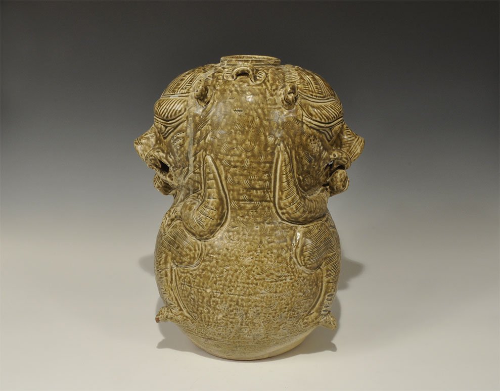 Cambodian Bifacial Bear Vessel: An undated archaistic brown-glazed ceramic vessel formed as an addorsed pair of bear figures, each crouching with one forepaw resting on a knee, the other raising food to the mouth; tw suspension lugs