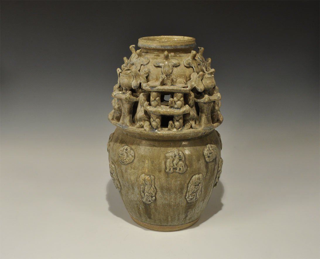 Cambodian Complex Glazed Lamp: An undated archaistic green-glazed ceramic vessel with bulbous body and recessed rim; to the body, figural appliques in tow rows; to the shoulder a frieze of separately modelled kneeling figures, four