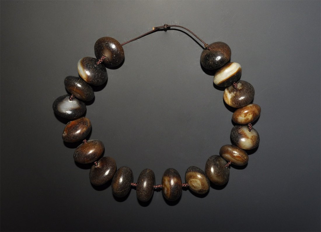 Tibetan Banded Agate Buddhist Necklace: A restrung necklace of eighteen undated oblate banded agate beads on a modern cord. Acquired on the London art market in the 1960s. 726 grams, 58 cm (22 3/4").