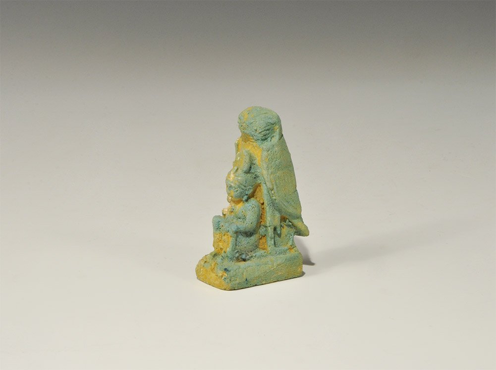 Egyptian Style Glazed Composition Harpocrates Figurine: An undated archaistic blue glazed composition depicting the seated god Harpocrates with finger to his lips, resting against a standing falcon on a rectangular base. Acquired on the London art market i