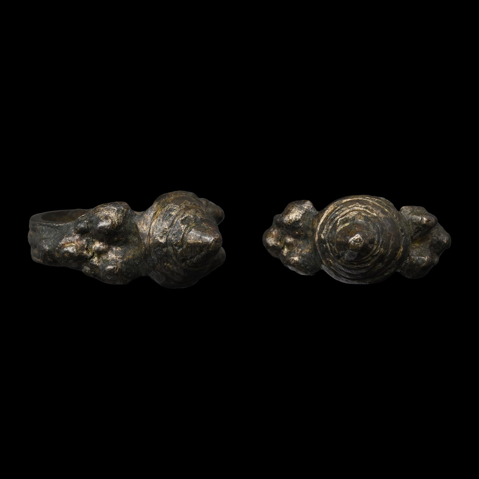 Byzantine Bronze Architectural Ring: Circa 6th-8th century A.D. Grooved hoop with raised rosettes on the shoulders, tall conical bezel with incised concentric circles. 9.31 grams, 30.06 mm overall, 18.90 mm internal diameter (approximate