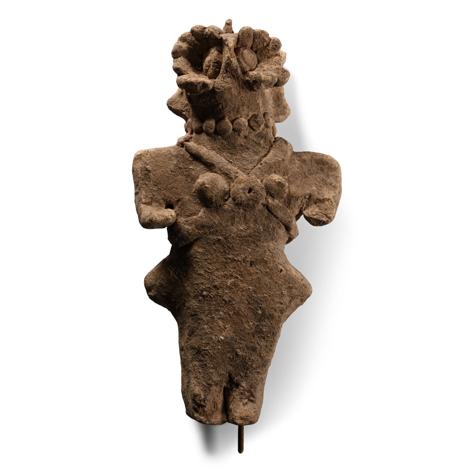 Amorite Terracotta Idol of a Standing Woman: 3rd-2nd millennium B.C. Modelled in the round female figure standing with stub arms, applied breasts and pectoral cross-straps with central disc; applied collar of discs and mask with segmented detail