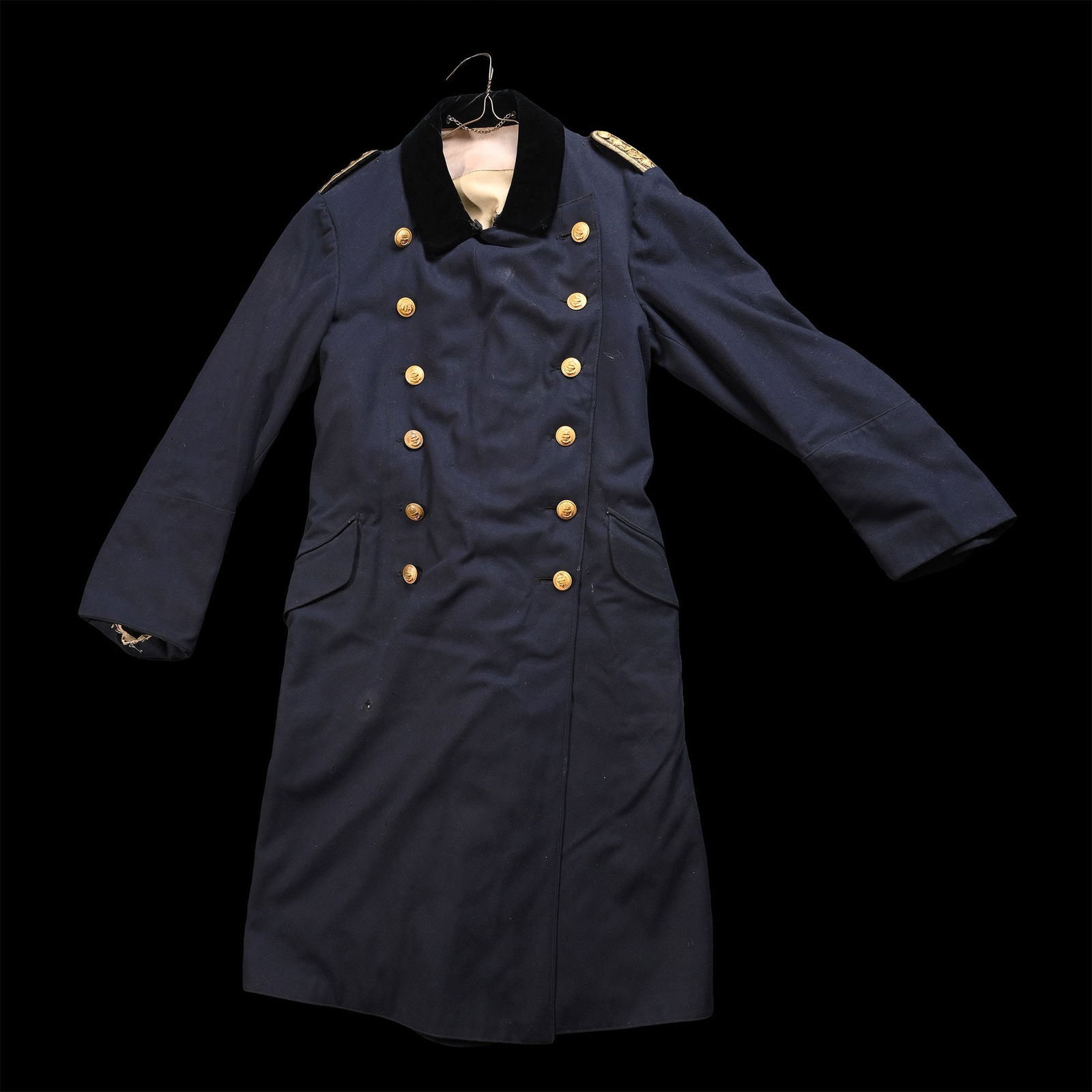 German WWI Kaiserliche Marine Naval Officer's Frock Coat: 1914-1918 A.D. Dark blue fabric knee-length overcoat with satin lining, black velvet stand-and-fall collar with hook-and-eye closure, twelve gilt buttons to the front with Kriegsmarine insignia and se