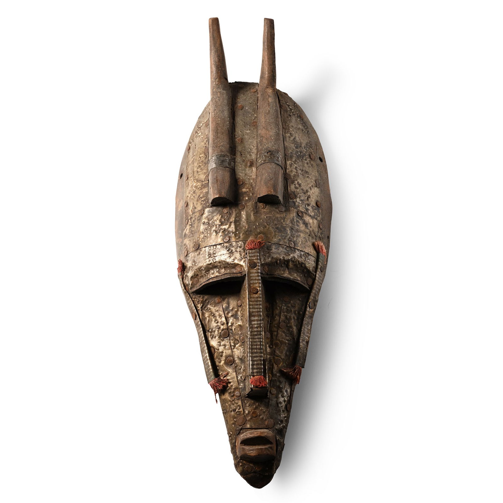 African Wooden Ceremonial Face Mask: Bambara Tribe, 20th century A.D. A small wooden carved mask with curved horns, decorated with thin metal sheets and fabric tufts. 234 grams, 30 cm (11 3/4 in.). [No Reserve] From Mali, West Africa. Fr
