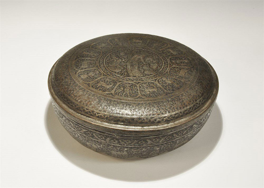 Islamic Style Bronze Ornamental Lidded Bowl: An undated archaistic bronze bowl with a frieze to the side of leaping deer and kneeling women with flasks and goblets on a field of vegetation; the lid with outer band of flowers and leaves, surround