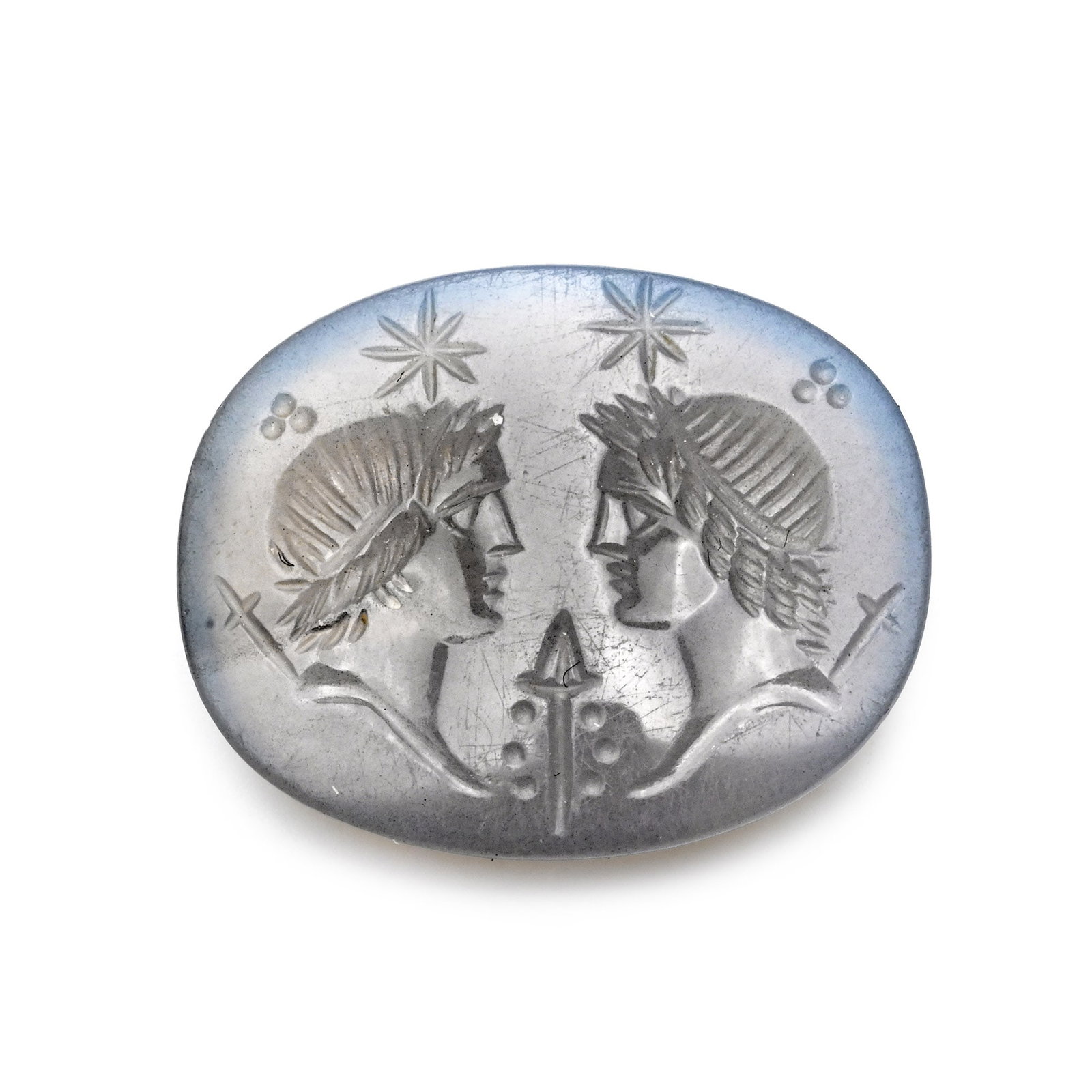 Post-Classical Chalcedony Gemstone with Two Facing Busts of the Dioscuri: 19th century A.D. or later Incuse male profile busts with stars in the background and other objects in the field; supplied with a museum-quality impression. 2.17 grams, 19 mm (3/4 in.). Acquired on th