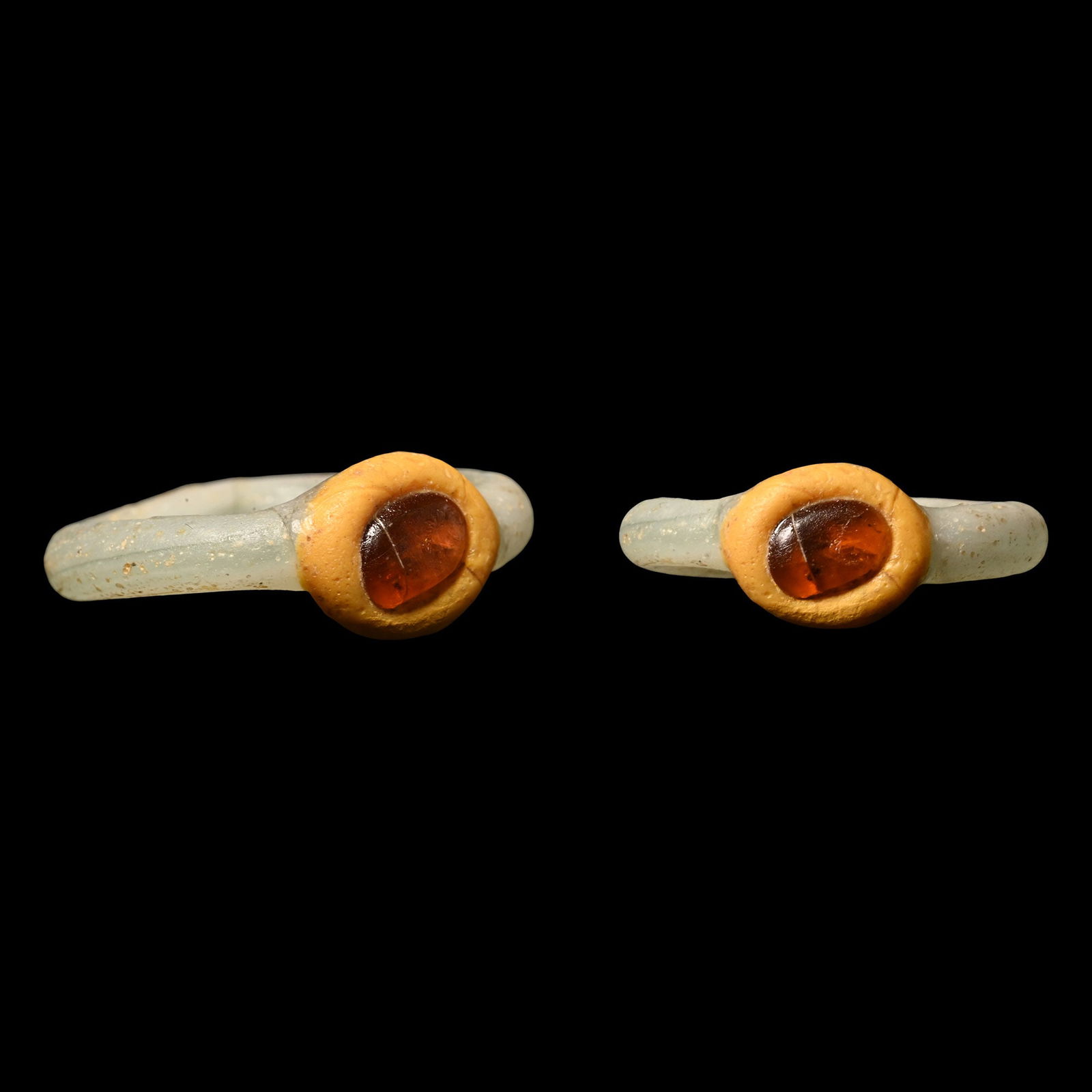 Roman White and Orange Glass Ring with Amber Inlay: 2nd-3rd century A.D. Round section hoop, oval bezel set with amber. Bagot 2012, The Hephaestus Legacy, no.513 & 515. 1.30 grams, 21.04 mm overall, 13.89 x 14.39 mm internal diameter (approximate size