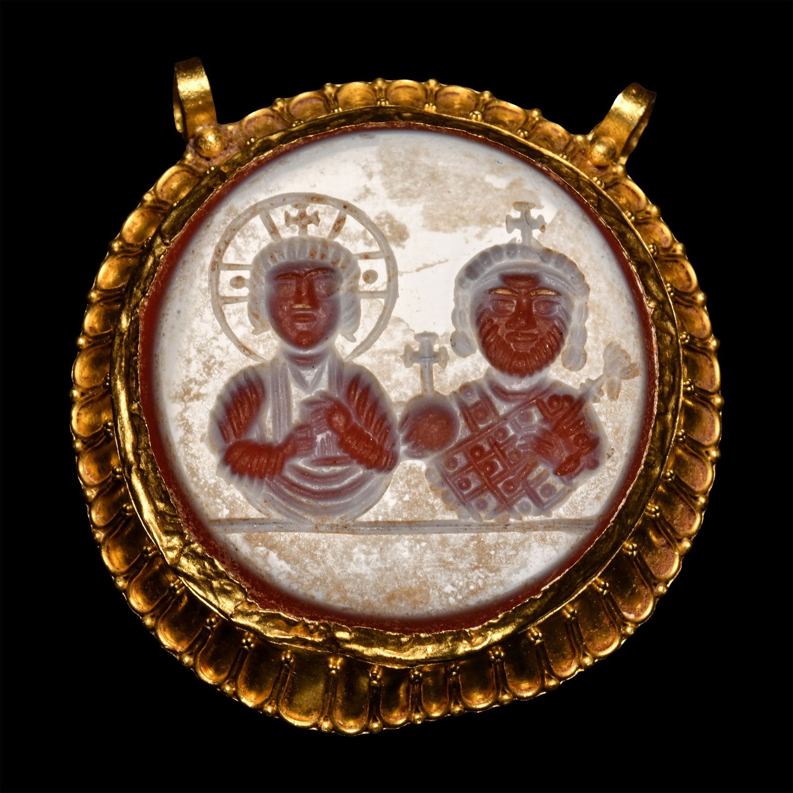 Large Byzantine Style Agate Gemstone in Gold Pendant: 18th-19th century A.D. Discoid cell with scooped rim and faux-granulated segments; two granule-and-loop suspension points; incuse frieze of two facing figures, one crowned and holding an orb and scept