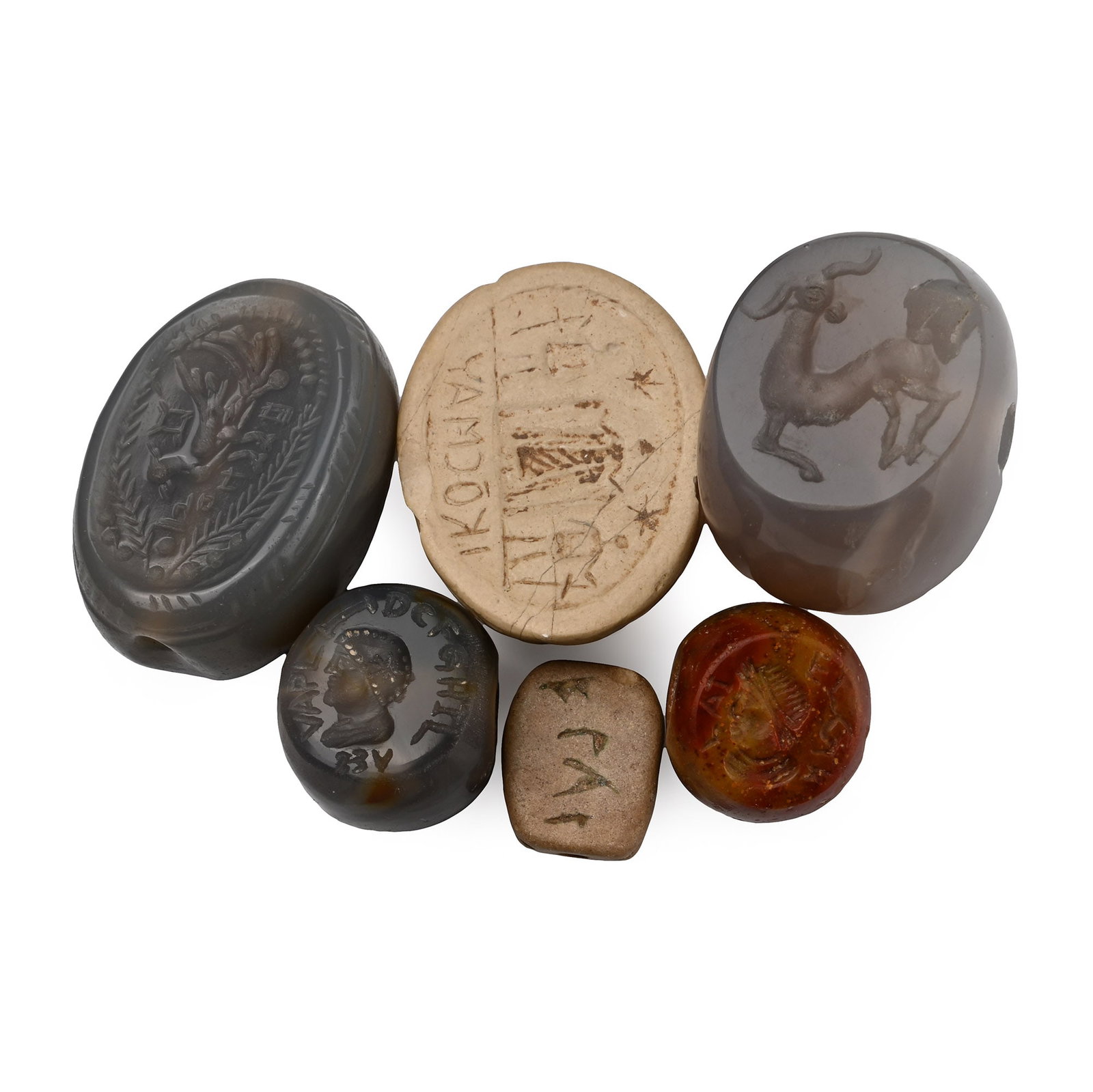 Group of Seals and Scaraboids: 20th century A.D. Including scarab with figural scene and legend to underside, plano-convex type with wreath, perching bird and legend, and other types; after the antique. 78 grams total, 15-33 mm (1/