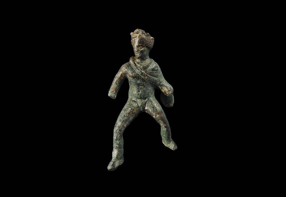 Greek Macedonian Bronze Riding Figure of Alexander the: After 323 BC. A cast figurine of Alexander The Great, nude with a cloak over his left shoulder and wreath to his head, legs spread; facial detail carefully modelled. 29 grams, 58 mm (2 1/4"). Ex Moros