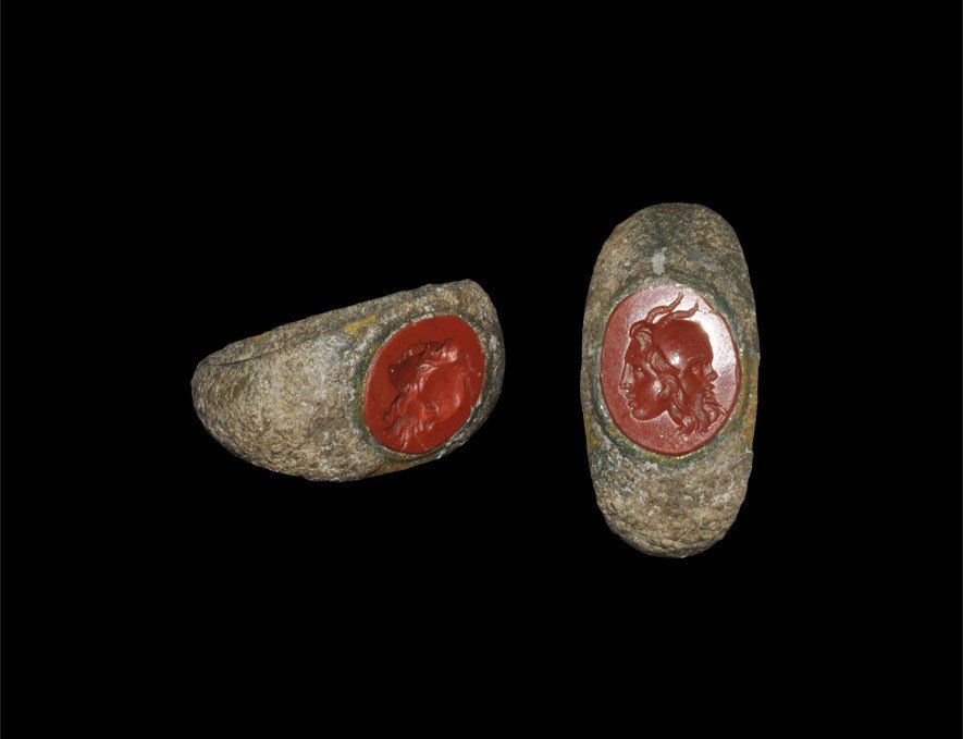 Roman Bronze Finger Ring with Female Bust Intaglio: 2nd-3rd century AD. A D-section hoop expanding to broad shoulders and inset elliptical jasper intaglio with female bust motif. 4.30 grams, 23 mm overall, 17.70 mm internal diameter (approximate size B