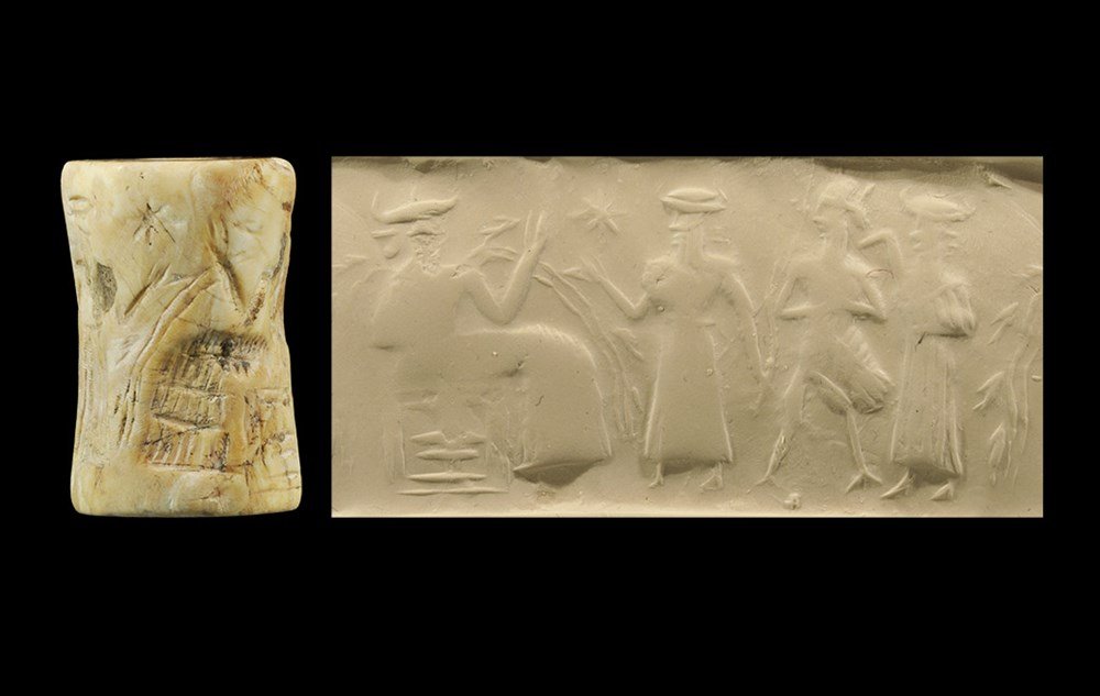 Near Eastern Akkadian Cylinder Seal with Judgment Scene: 2300-2200 BC. A cylinder seal made from a fossil shell, depicting the water-god Enki, long robe and tiara, water and fishes coming from his shoulders, before him servants holding a bird-man, Venus in 