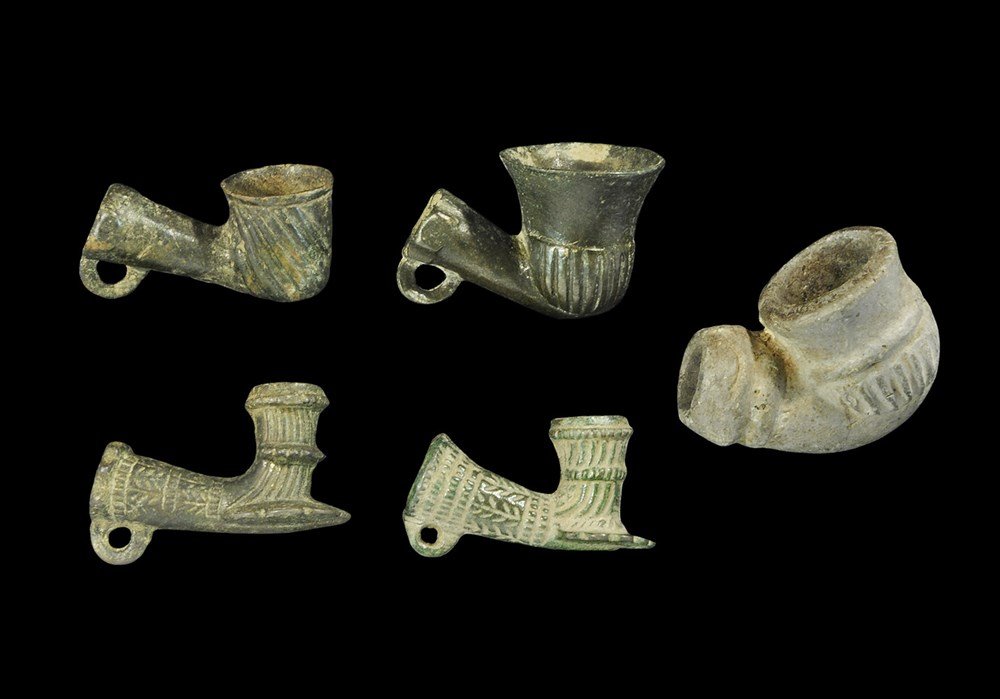 Ottoman Bronze and Ceramic Smoking Pipe Collection: 14th-17th century AD. A mixed group of cast smoking pipe bowls comprising: two with rosette plaque, ribbed surface, loop beneath the collar; one with thimble-shaped ribbed bowl, plain tube, loop; one 