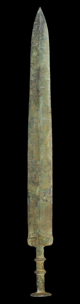 Chinese Bronze Short Sword: Han Dynasty, 206 BC-220 AD. A cast bronze short sword with central midrib to the waisted blade; elliptical guard, two transverse discoid collars to the grip and large discoid pommel above. 907 grams, 