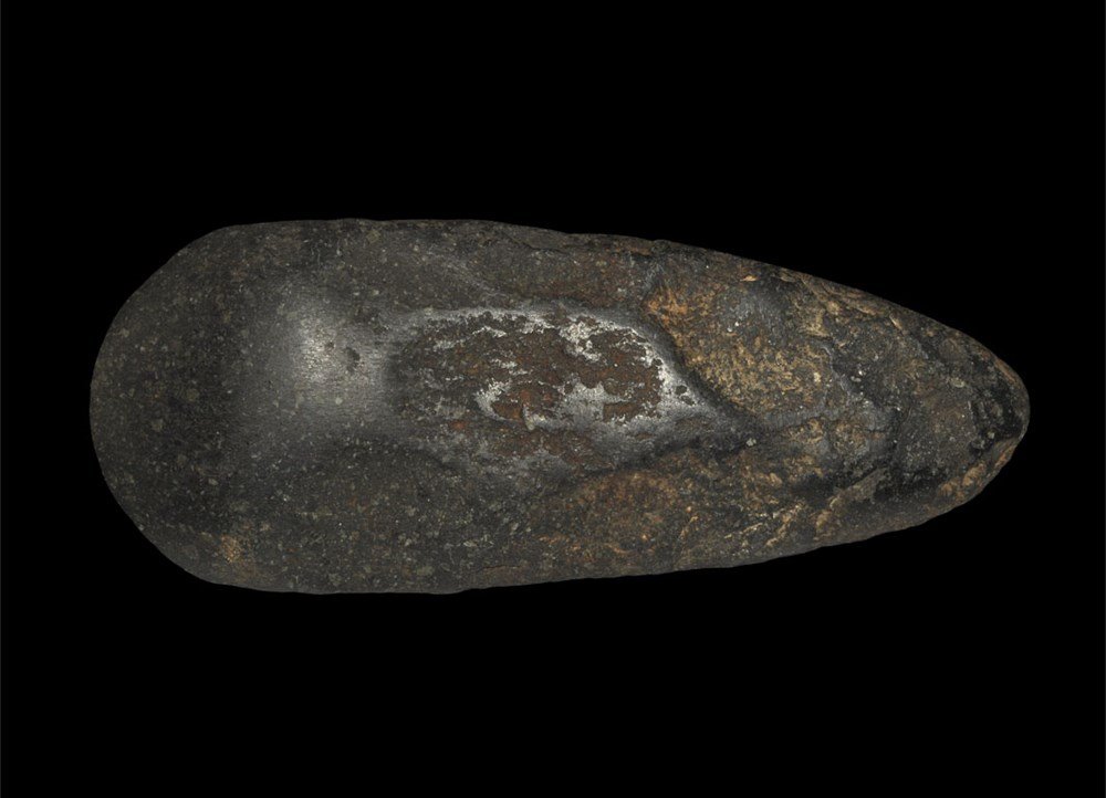 Stone Age Neolithic Polished Epidiorite Axe: 5000-3000 BC. A large pecked and polished axe with broad, convex cutting edge and narrow rounded butt; formed in a black epidiorite material. 736 grams, 19 cm (7 1/2"). Ex Dr. M. G. Weller collection;