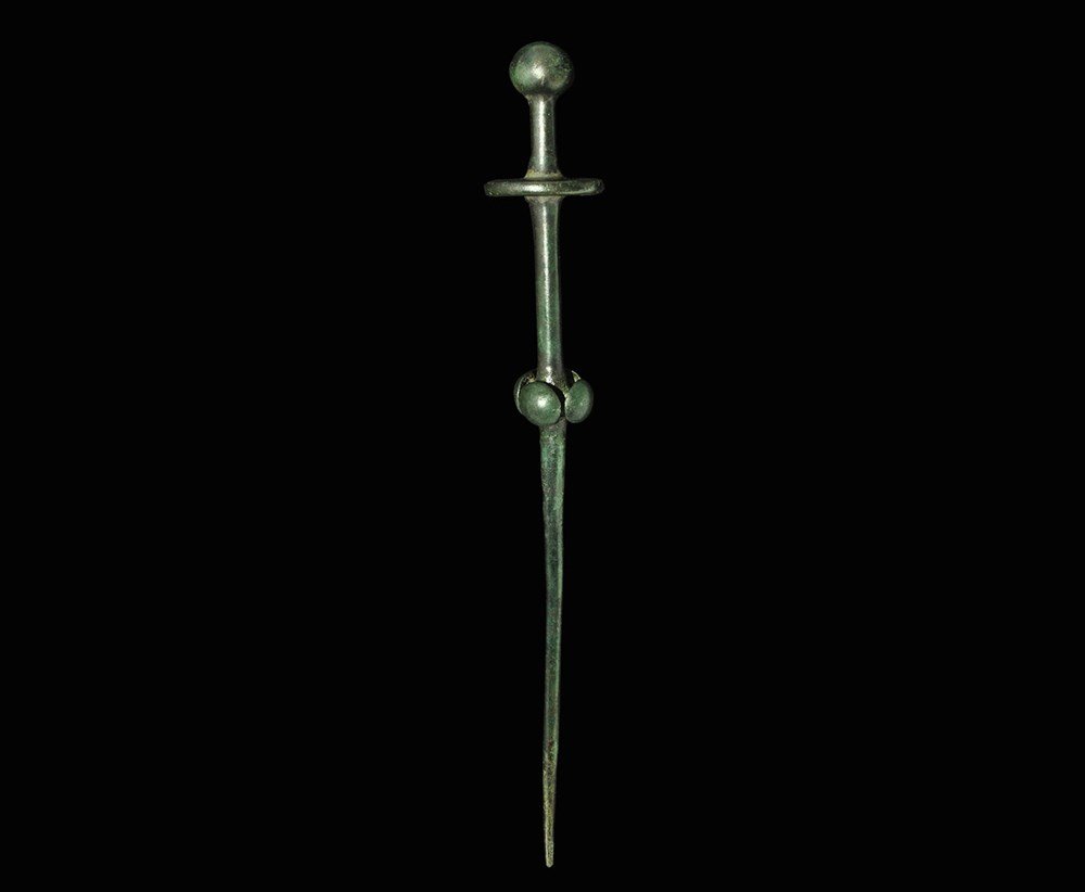 Bronze Age Large Cloak Pin: 1500-900 BC. A central European bronze cloak pin of unusual form with spherical terminal, a projecting disc collar and a second collar of four mushroom-headed bosses. 45.58 grams, 20 cm (8"). Property