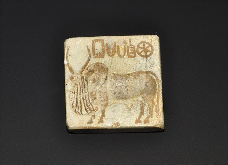Central Asian Style Serpentine Stamp Seal with Animal: An undated archaistic carved stone stamp seal with pierced boss to the reverse, intaglio motif of a standing bovine with script above. 37 grams, 39 mm (1 1/2"). Acquired on the London art market in th