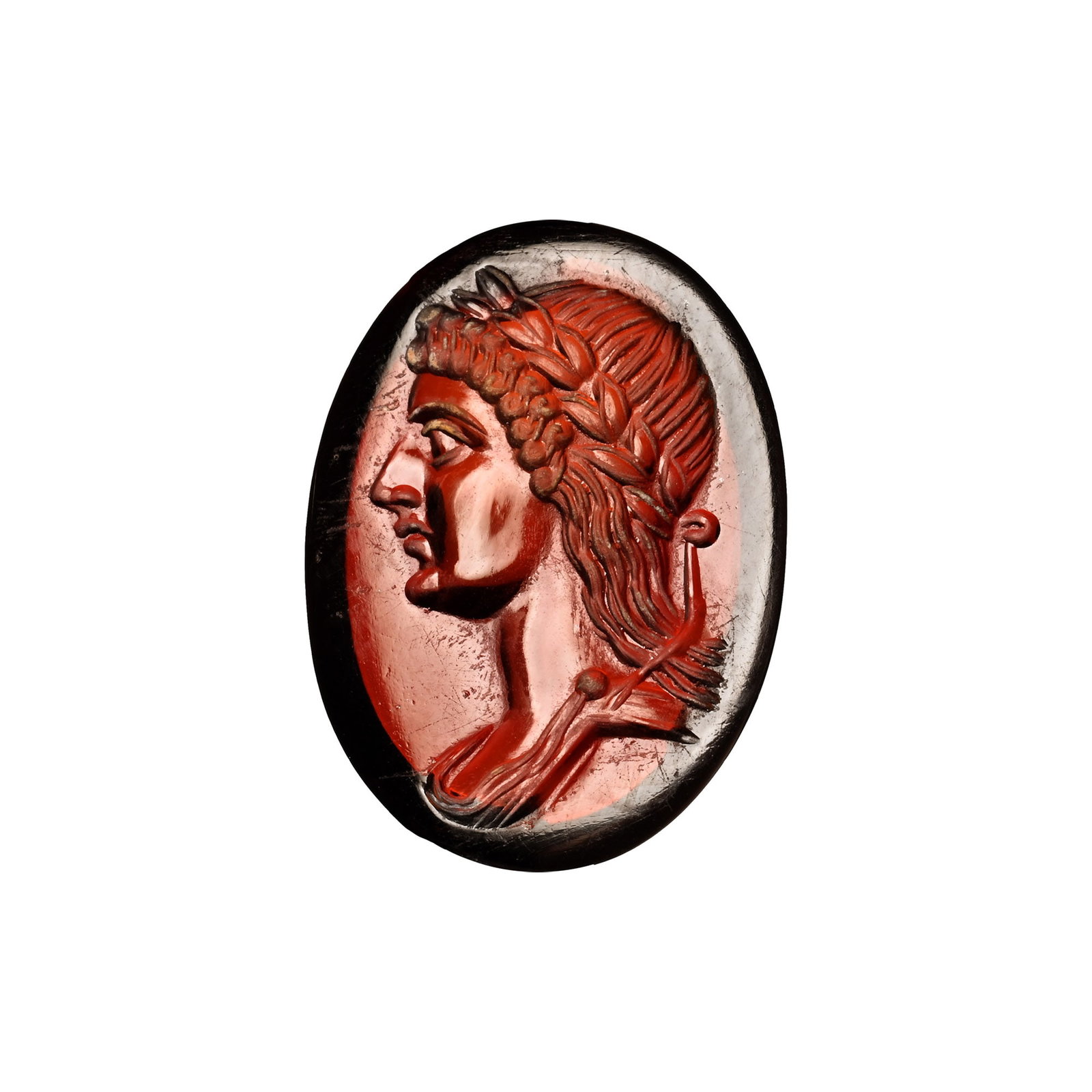 Roman Garnet Gemstone with Apollo: 2nd-3rd century A.D. Ellipsoid in plan with intaglio profile bust of Apollo with long cascading hair on the shoulders, braided wreath to the brow. 1.59 grams, 18 mm (3/4 in.). Private collection, 1990